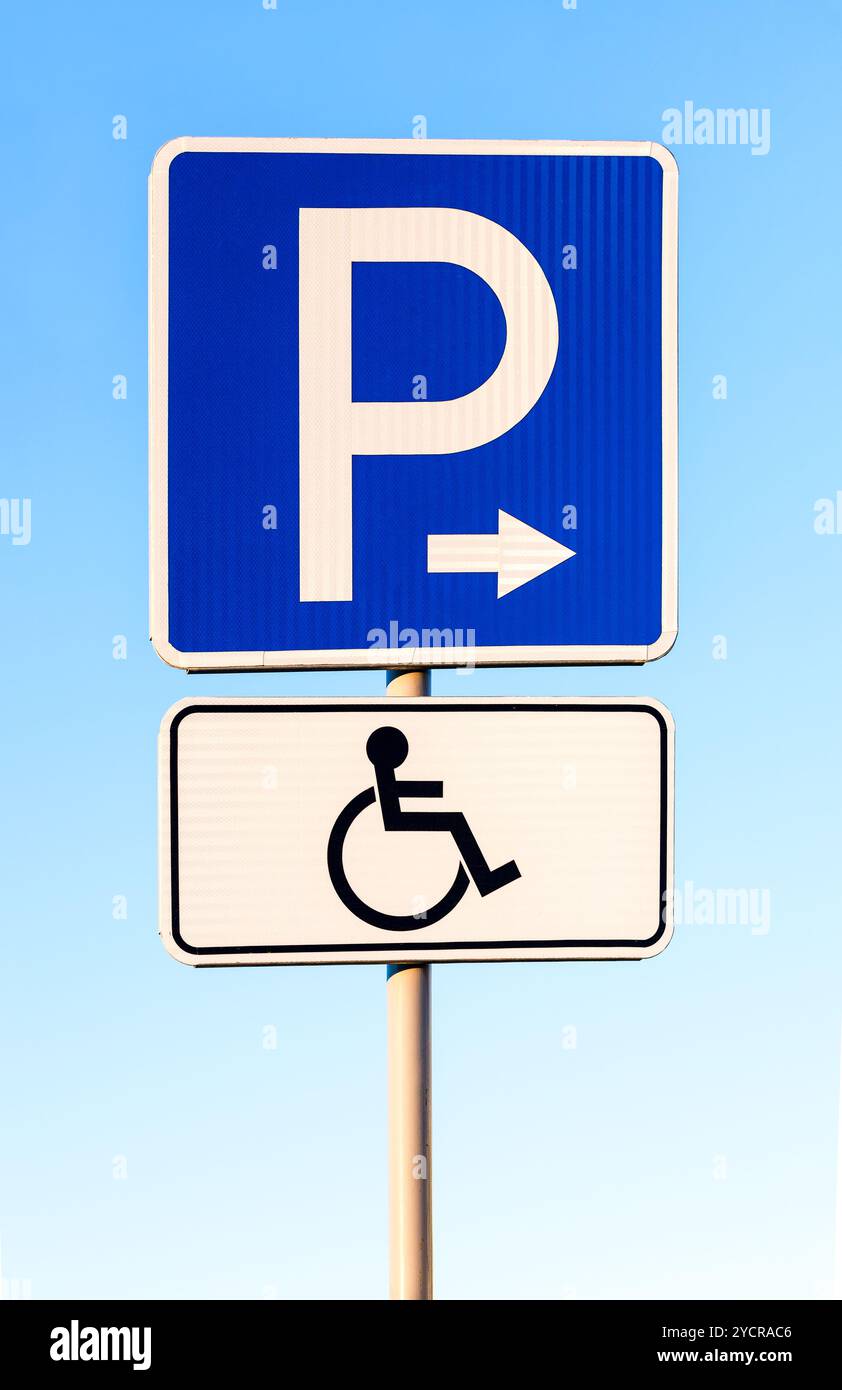 Nahaufnahme von einem behinderten Parkplatz Schild gegen blauen Himmel Stockfoto