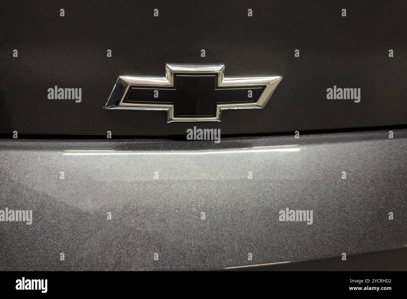 Nahaufnahme des Logos der Automarke Chevrolet in Form eines schwarzen Kreuzes auf der schwarzen Motorhaube des Autos, international Stockfoto