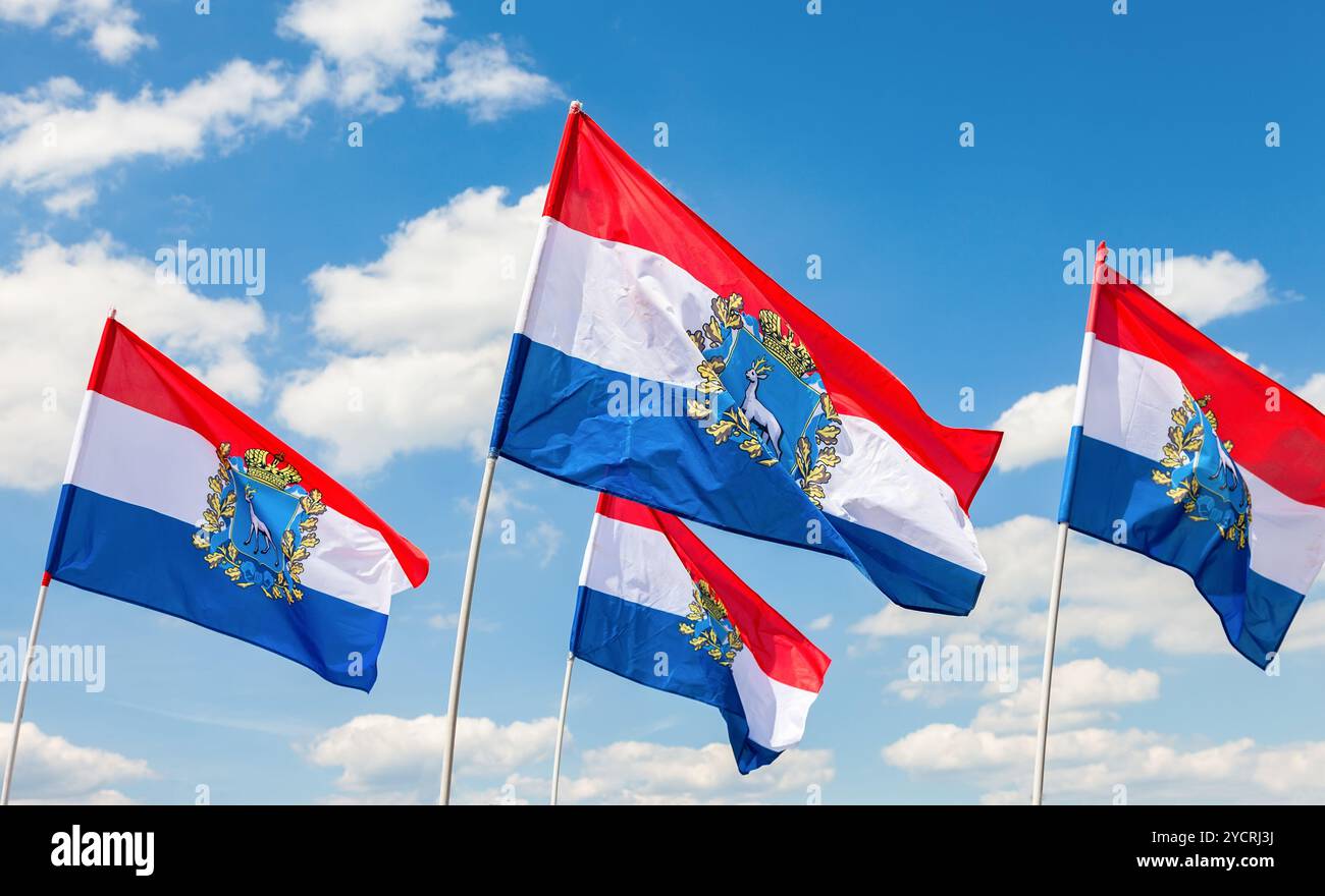 Flaggen der Bundesthemen von Rußland. Flaggen der Samara Region gegen den blauen Himmel flattern Stockfoto