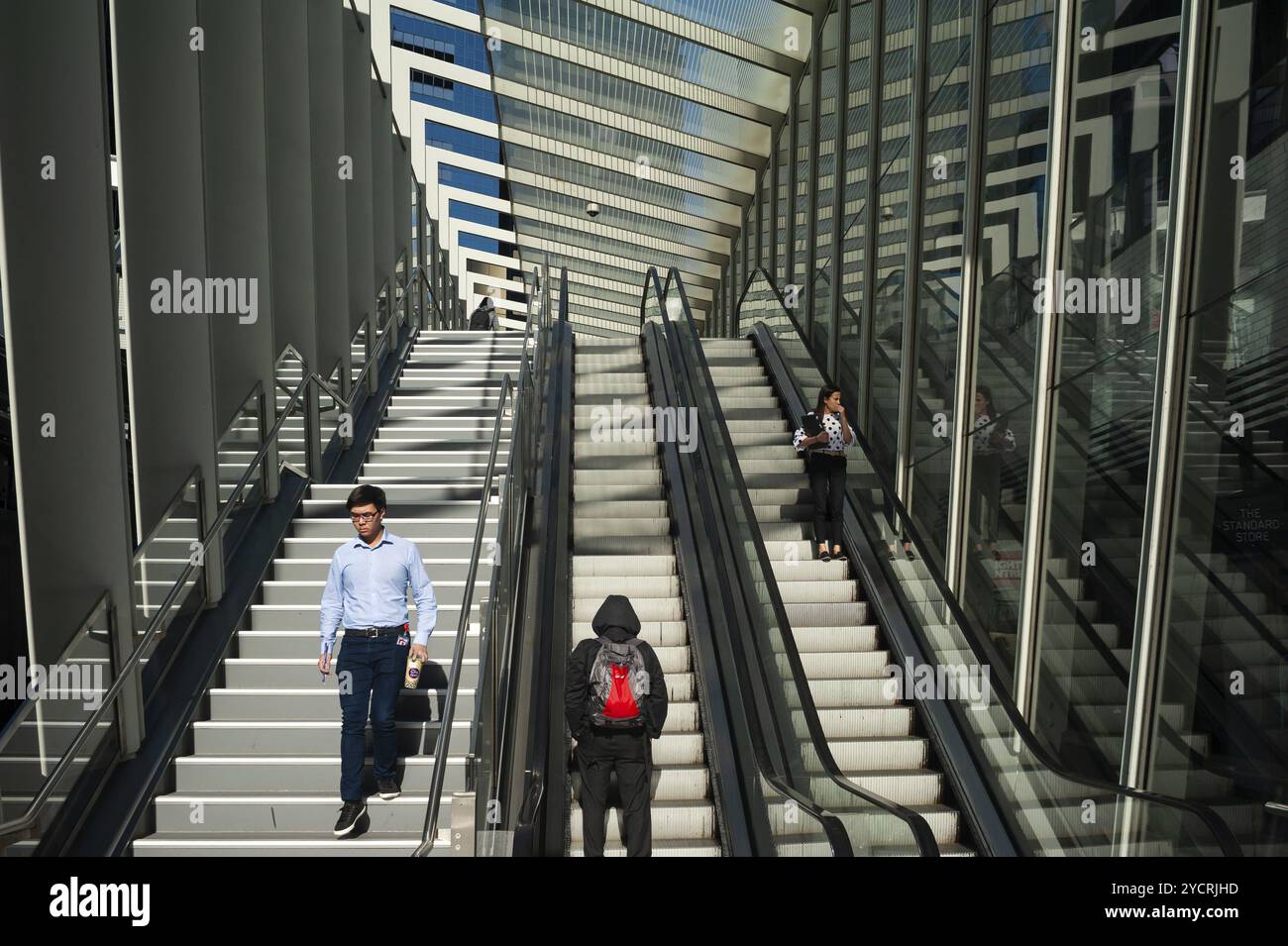 17.09.2018, Sydney, New South Wales, Australien, Menschen stehen auf einer Rolltreppe, die zur überdachten Barangaroo-Fußgängerbrücke im Barangaroo South busi führt Stockfoto