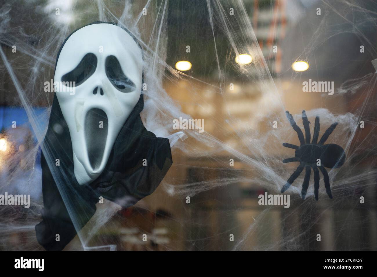 27.10.2018, Singapur, Republik Singapur, Asien, Eine Schrei-Maske und eine Spinnenpuppe hängen als Halloween-Dekoration in einem Schaufenster, Asien Stockfoto