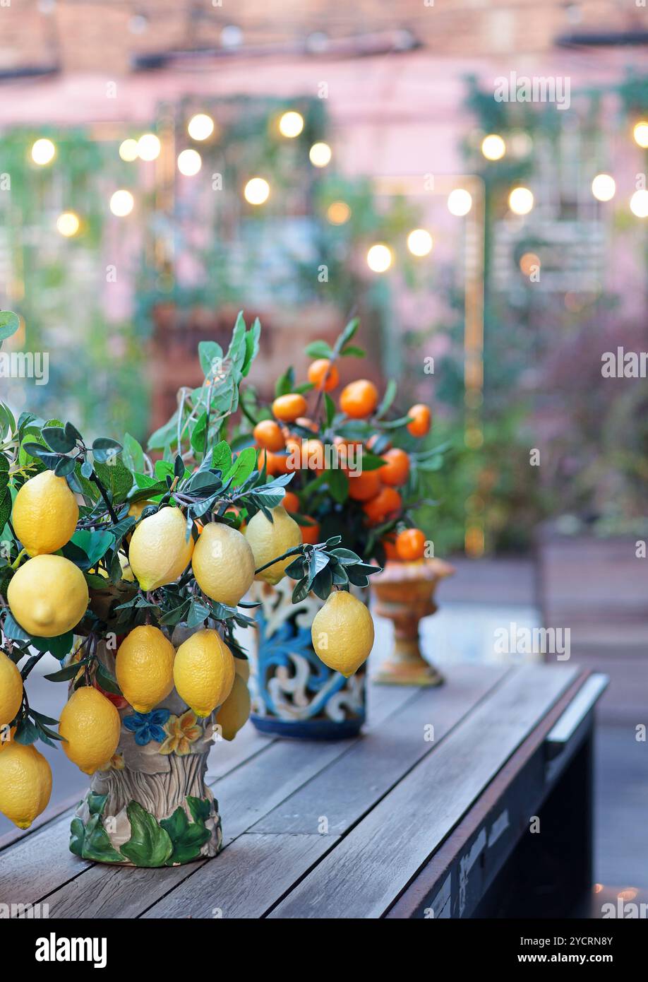 Zweig mit Zitronen, Mandarinen in Keramikvase auf dem Tisch. Traditionelles Muster, Sizilien, Italien. Obst und Einrichtung. Stockfoto