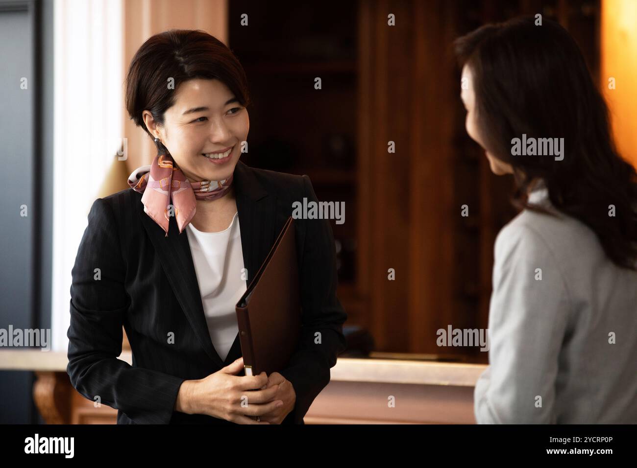 Frau an der Rezeption, die Gäste bedient Stockfoto