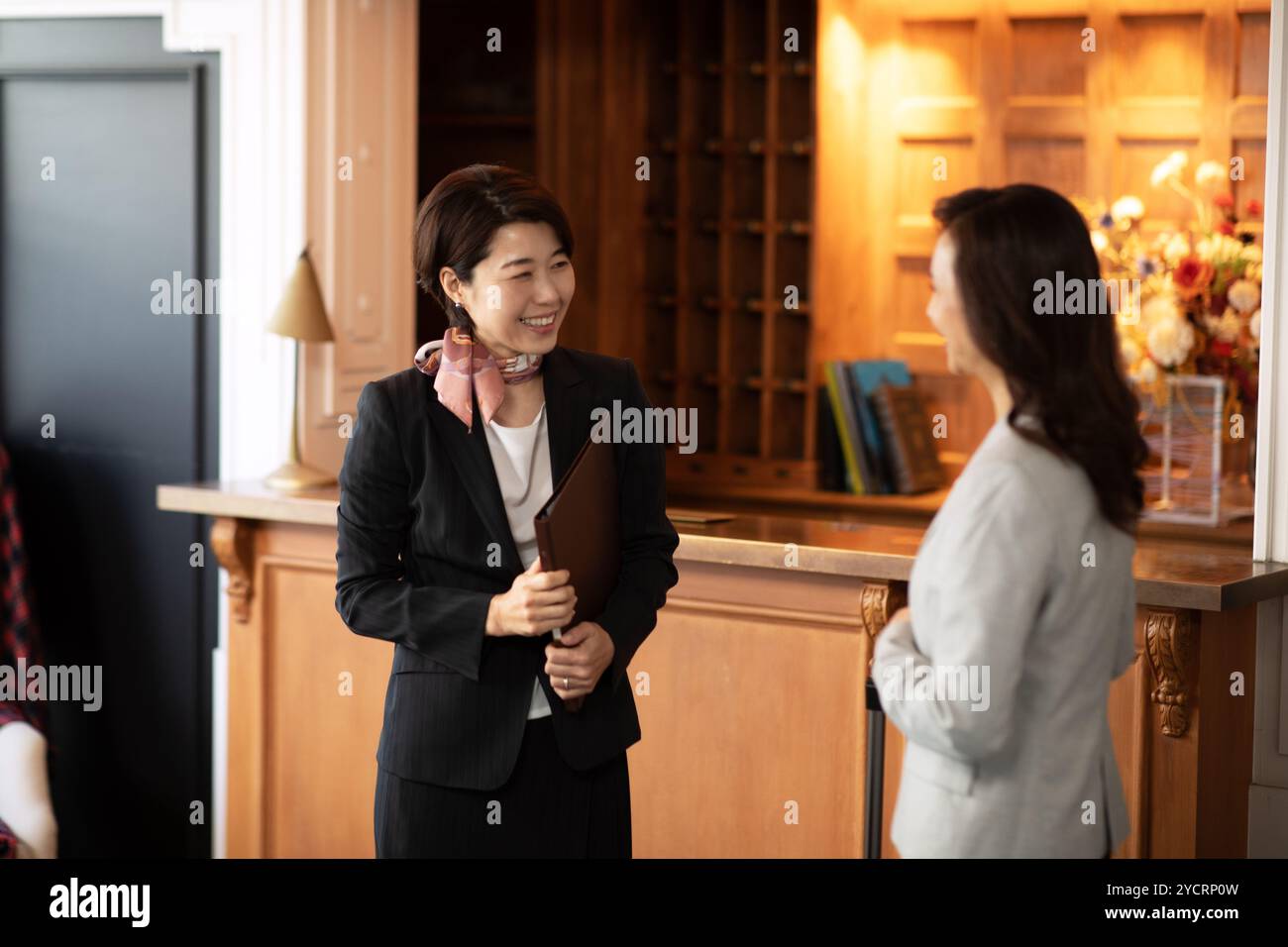 Frau an der Rezeption, die Gäste bedient Stockfoto
