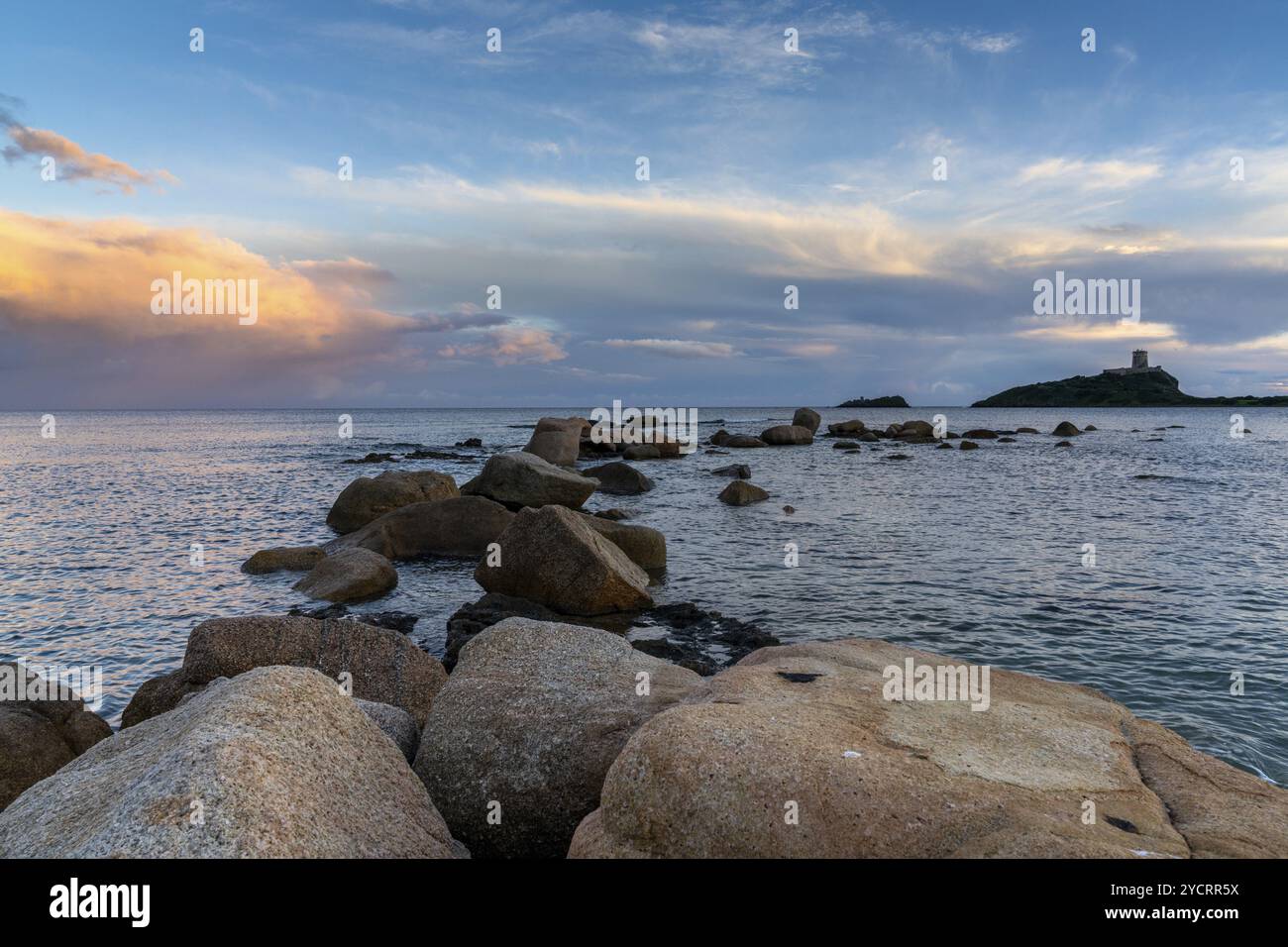 Landschaftsblick auf einen farbenfrohen Sonnenuntergang am Nora Beach in Sardinien mit dem Coltellazzo Tower im Hintergrund Stockfoto