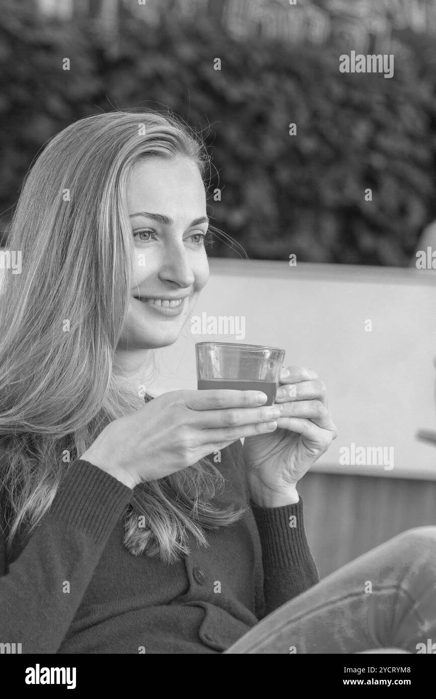 Frau mit Teetasse. Tee mit Sanddorn und Honig auf Café-Hintergrund. Stockfoto