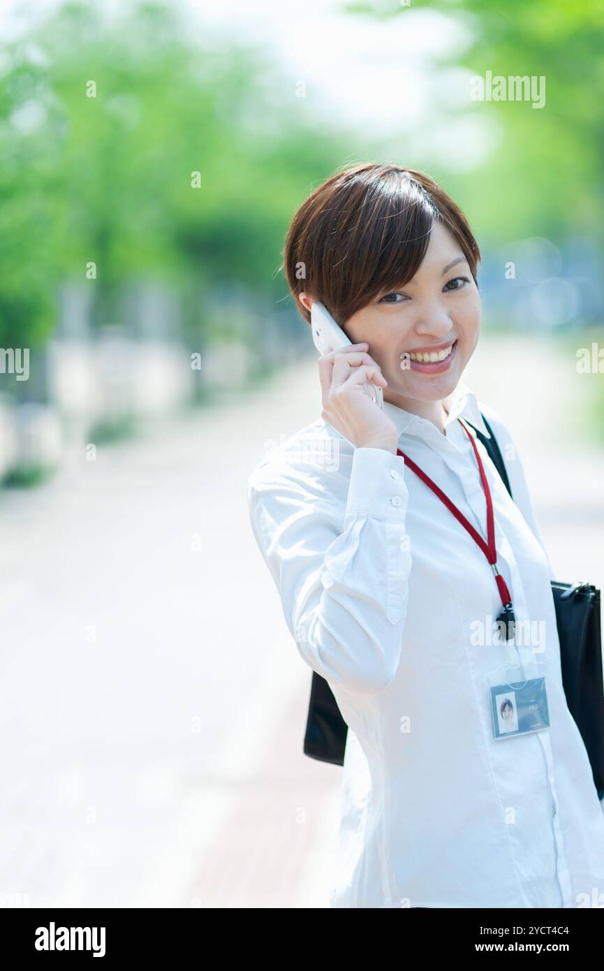 Büroangestellte, die über ein Smartphone sprechen Stockfoto