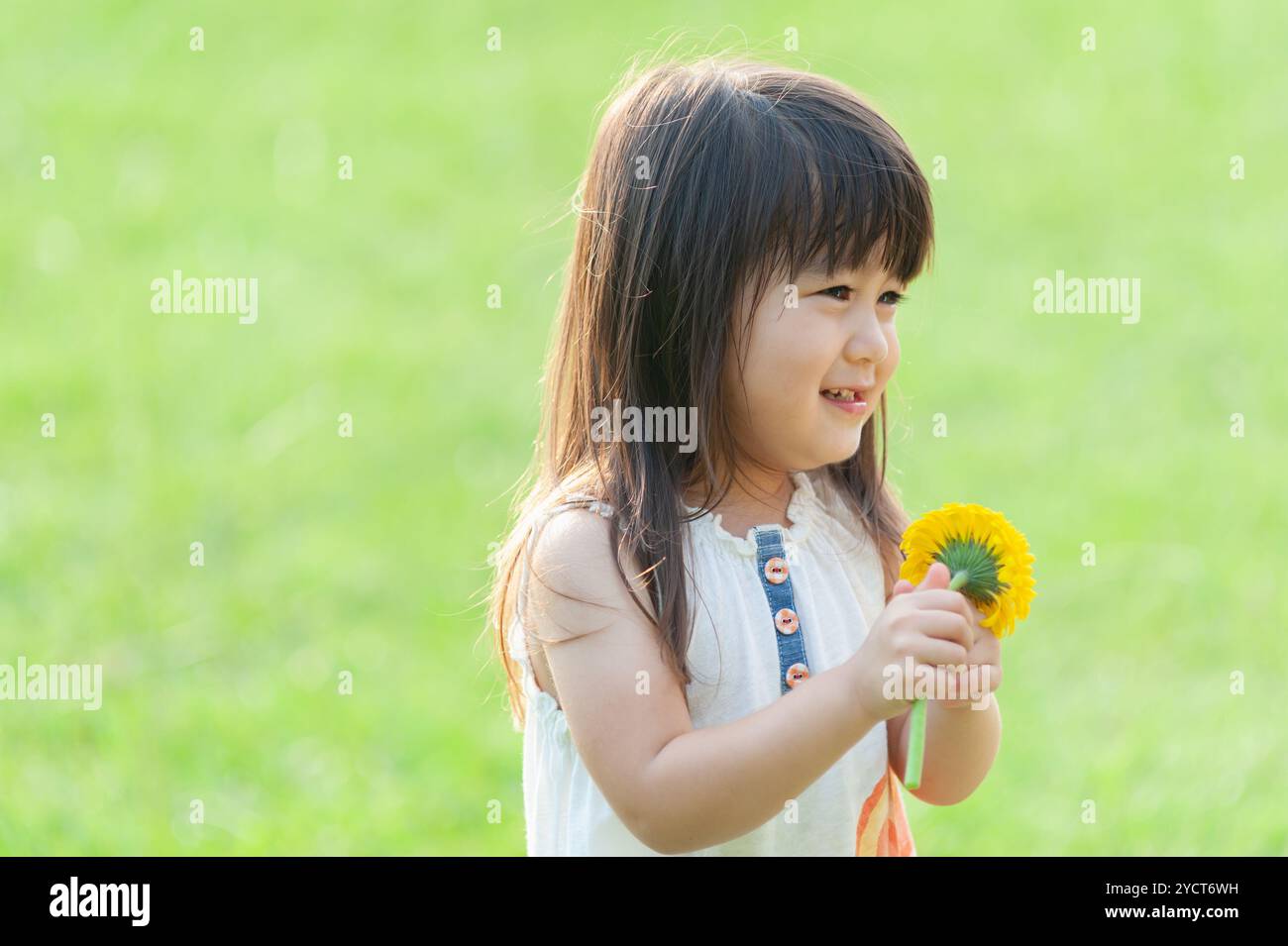 Lachendes Mädchen, das Blumen hält Stockfoto