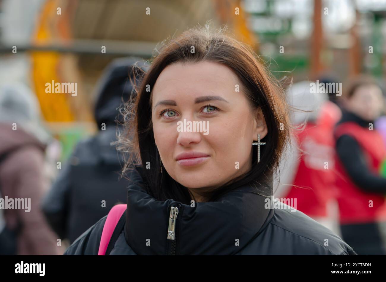 Straßenporträt einer schönen Frau 30-35 Jahre alt vor einem verschwommenen Stadthintergrund. Stockfoto