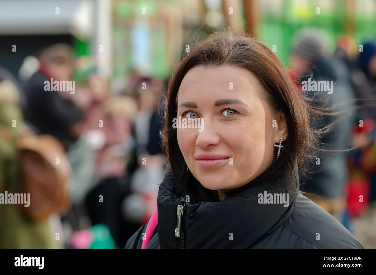 Straßenporträt einer schönen Frau 30-35 Jahre alt vor einem verschwommenen Stadthintergrund. Stockfoto