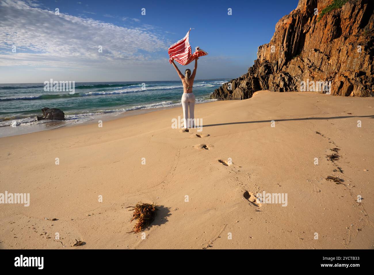 Eine Frau spaziert am Strand entlang, Reise, Gesundheit und Wohlbefinden Stockfoto