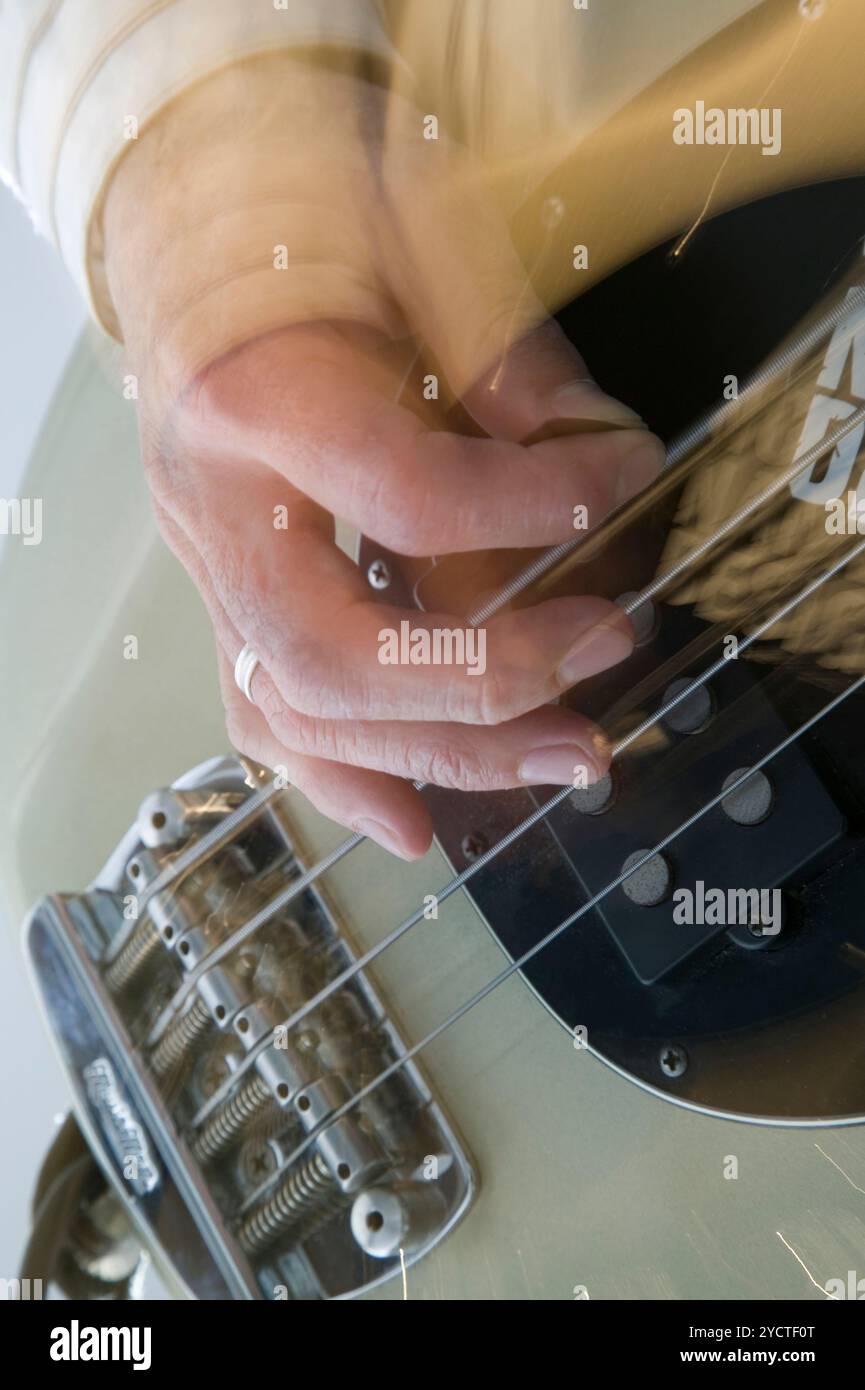 Hand, die Bass-Gitarre spielen Stockfoto
