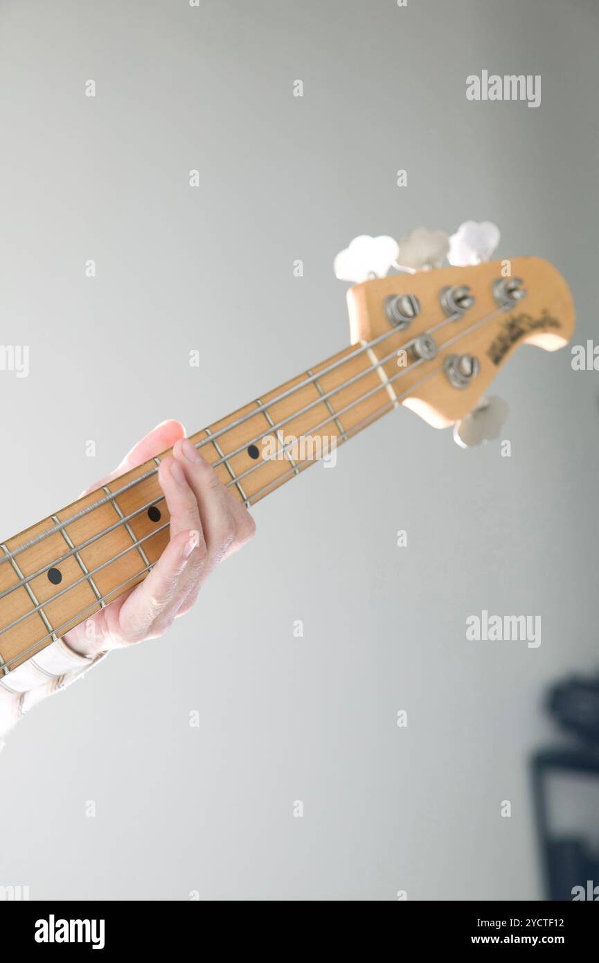 Hand, die Bass-Gitarre spielen Stockfoto