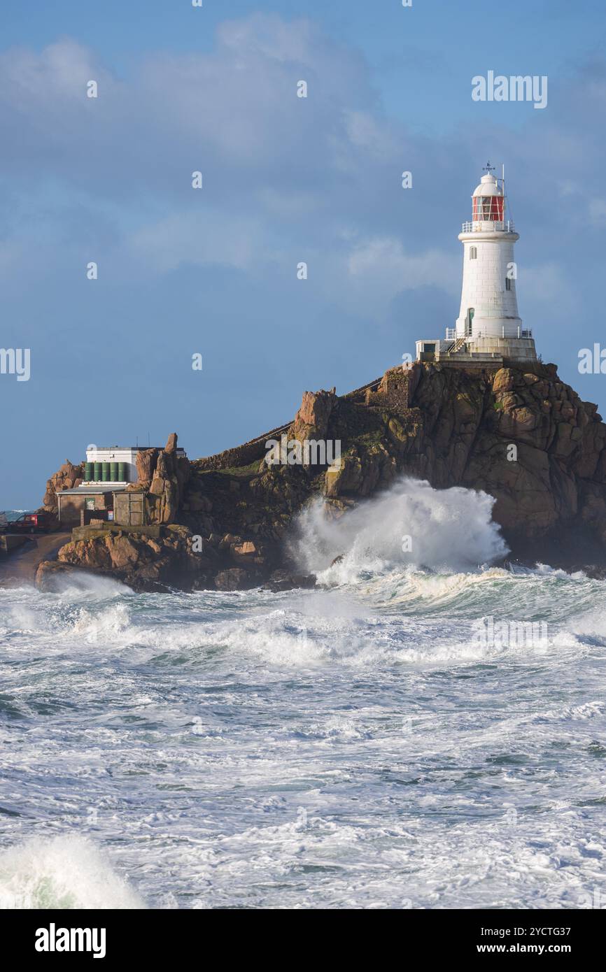 Der Leuchtturm La Corbiere auf einer felsigen Insel während eines Sturms und der Flut. Hohe Wellen krachen gegen Felsen. Stockfoto