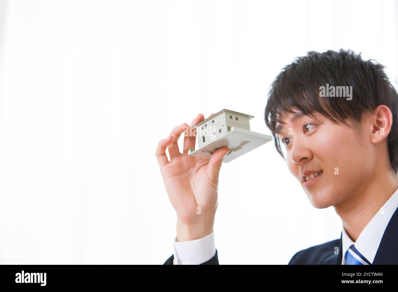 Männlicher Geschäftsmann, der sich ein Hausmodell ansieht Stockfoto