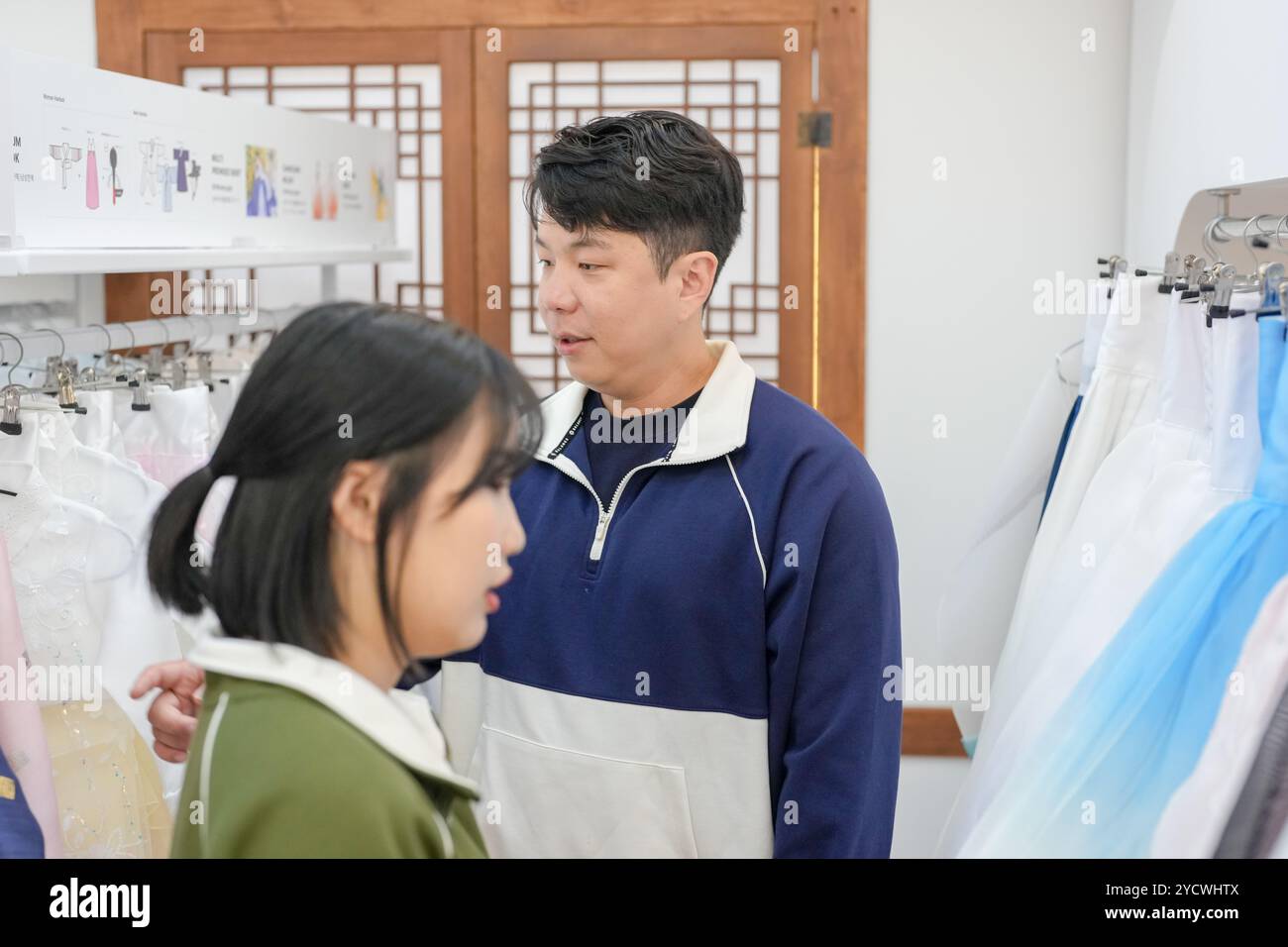 Ein koreanisches Paar, ein Mann in den 30ern und eine Frau in den 20ern, wählt harmonisch Kleidung für einen Hanbok-Verleih in Seoul, Südkorea. Stockfoto