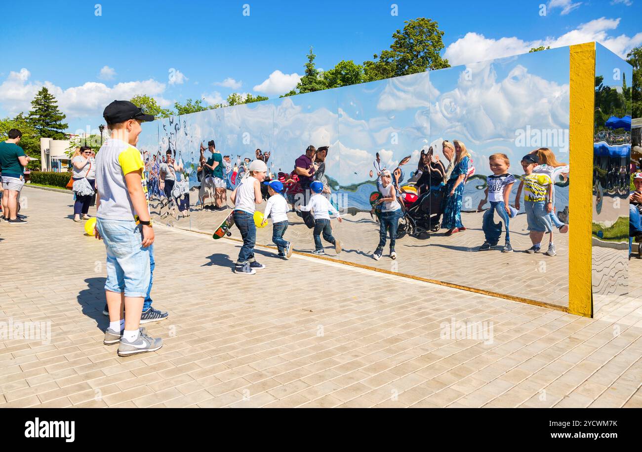 Menschen in der Nähe des riesigen Edelstahlspiegels im Stadtpark an sonnigen Sommertagen Stockfoto