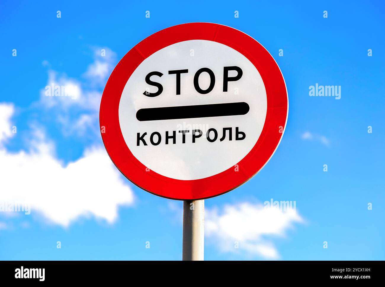 Verkehrszeichen HALTEN auf blauem Himmel. Text auf Russisch: Kontrolle Stockfoto