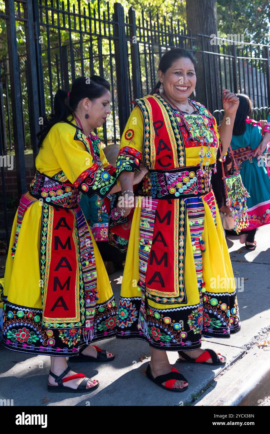 Ein Bolivianer mittleren Alters in der Pachamama Cultural Fraternity bekommt eine Kostümkorrektur. Vor der Bolivianischen Amerikanerparade in Queens, NY. Stockfoto