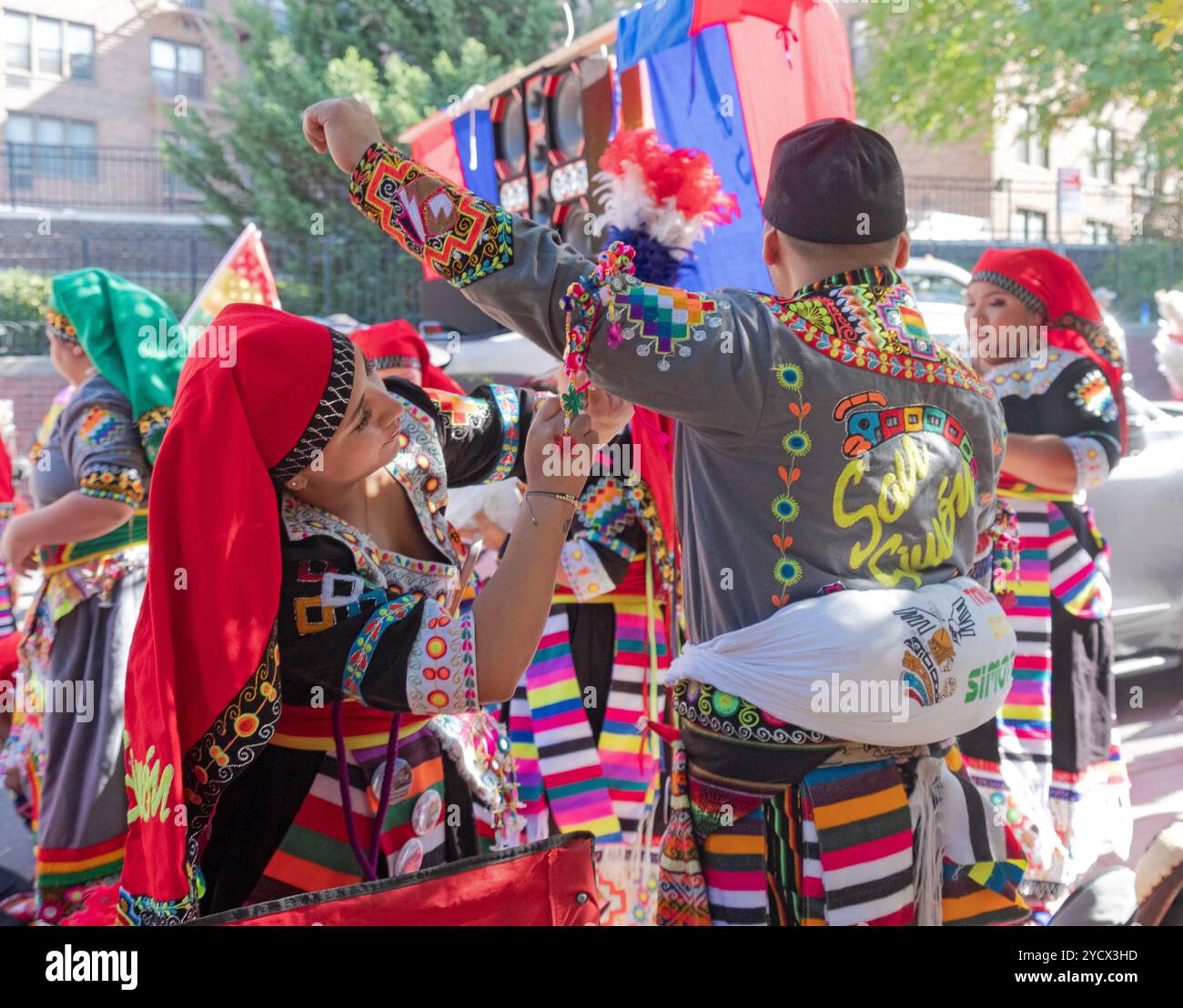 Die bolivianischen Amerikaner, die 2024 an der Bolivian Day Parade teilnahmen, passen ihre Kostüme in Jackson Heights, Queens, New York an. Stockfoto