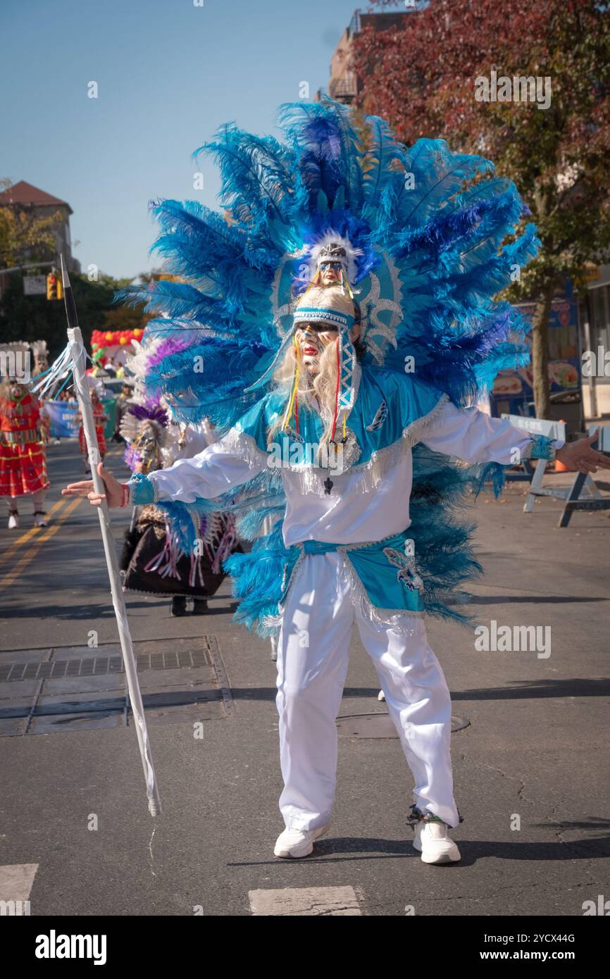 Tänzerin der Gruppe Centro Cultural Bolivien in einem Kostüm mit Maske und blauen Federn bei der Bolivian Day Parade in Jackson Heights, Queens, New York. Stockfoto