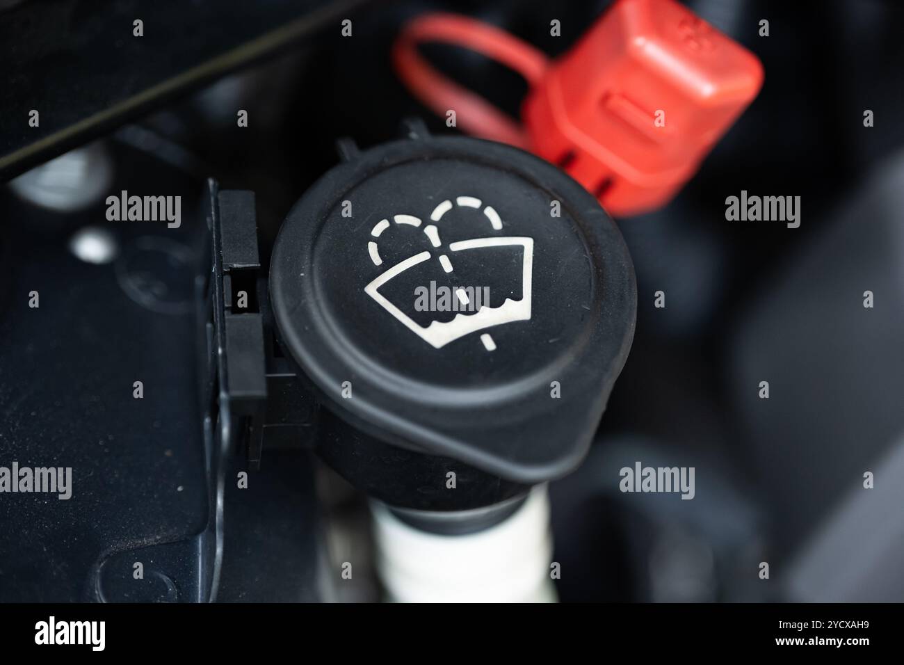 Symbol für Scheibenwaschflüssigkeit oder Scheibenwaschanlage auf dem schwarzen Einfülldeckel des Kunststoffbehälters. Nahaufnahme, keine Leute. Stockfoto