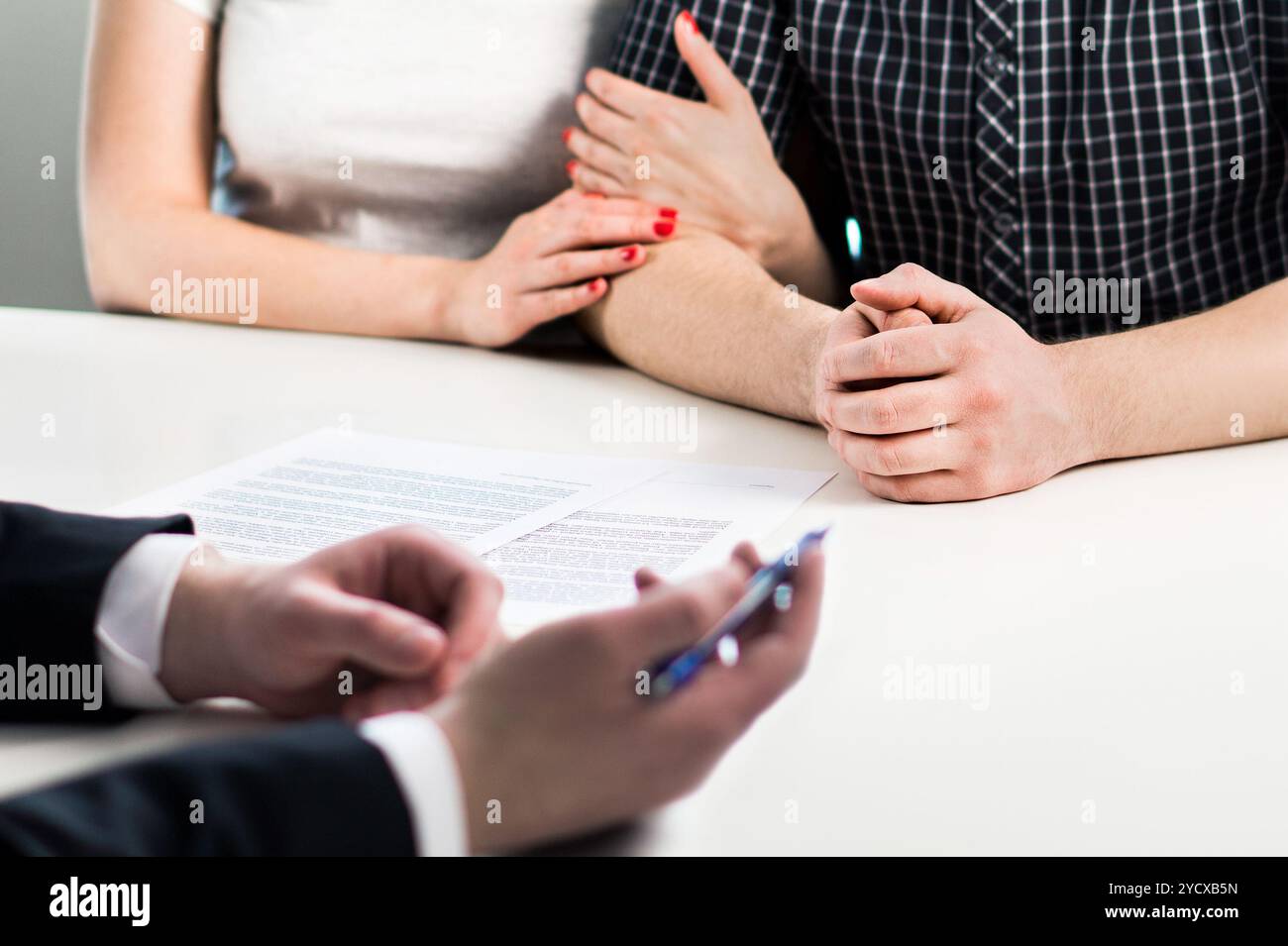 Ein Paar trifft sich mit einem Notar, einem Finanzberater oder einem Anwalt. Lebensversicherungsvertrag, Bankdarlehensabwicklung oder Investitionsvertrag. Stockfoto