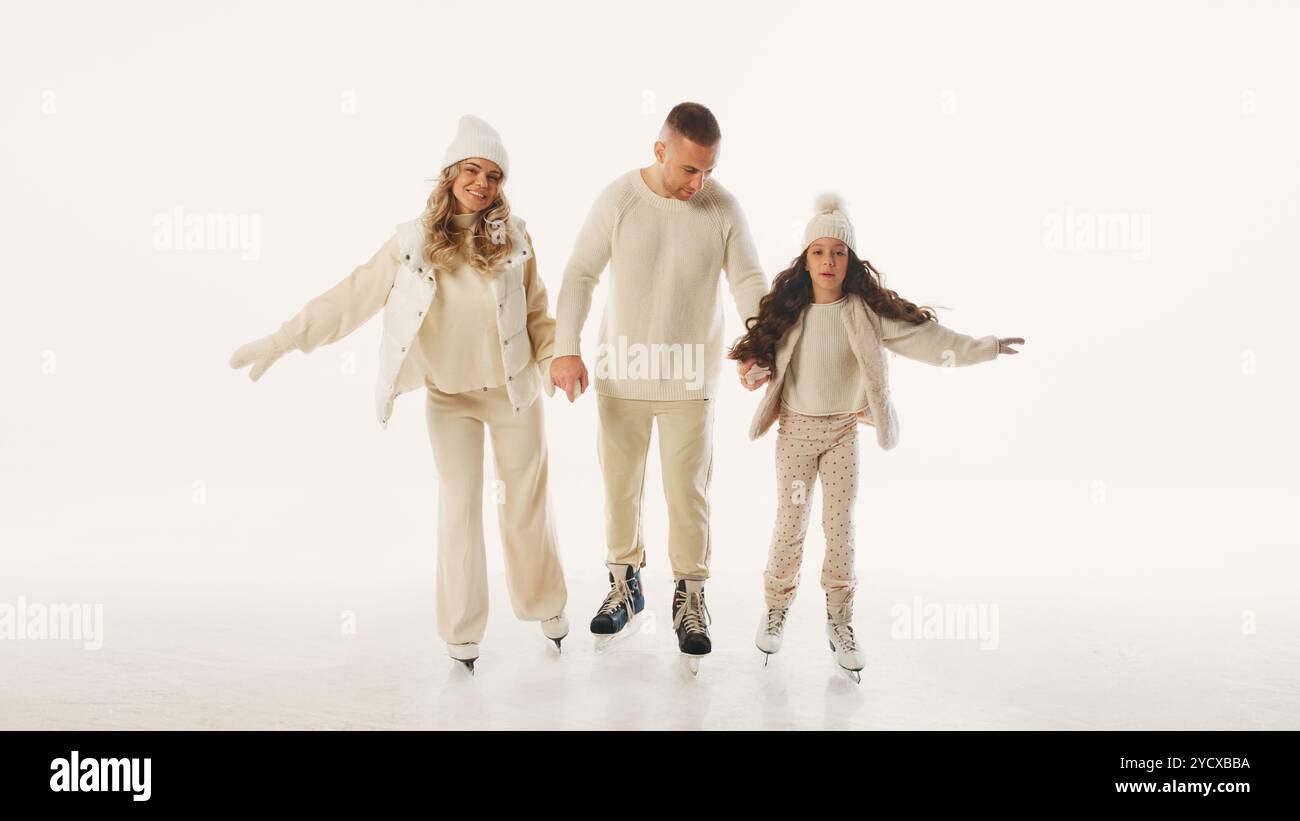 Die Familie genießt die Zeit auf der Eisbahn, lächelt und hält die Hände und fängt die Freude ein, während der Wintersaison schöne Zeit zusammen zu verbringen Stockfoto