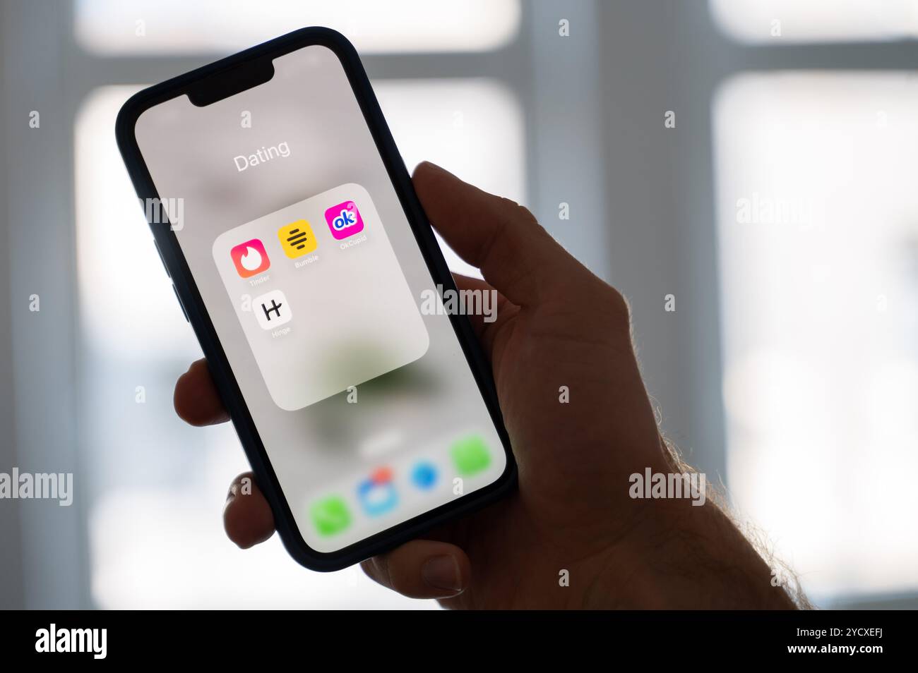 Hannover, Deutschland. Oktober 2024. ABBILDUNG - Eine Frau hält ein Smartphone, auf dem die Dating-Apps Tinder, Bumble, OkCupid und Scharnier angezeigt werden. Quelle: Alicia Windzio/dpa/Alamy Live News Stockfoto