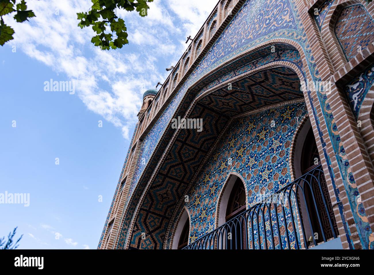 Dieses Bild zeigt das atemberaubende Detail der blauen und bronzefarbenen Fliesen, die ein architektonisch bedeutsames Gebäude in Alt-Tiflis zieren, gerahmt Stockfoto