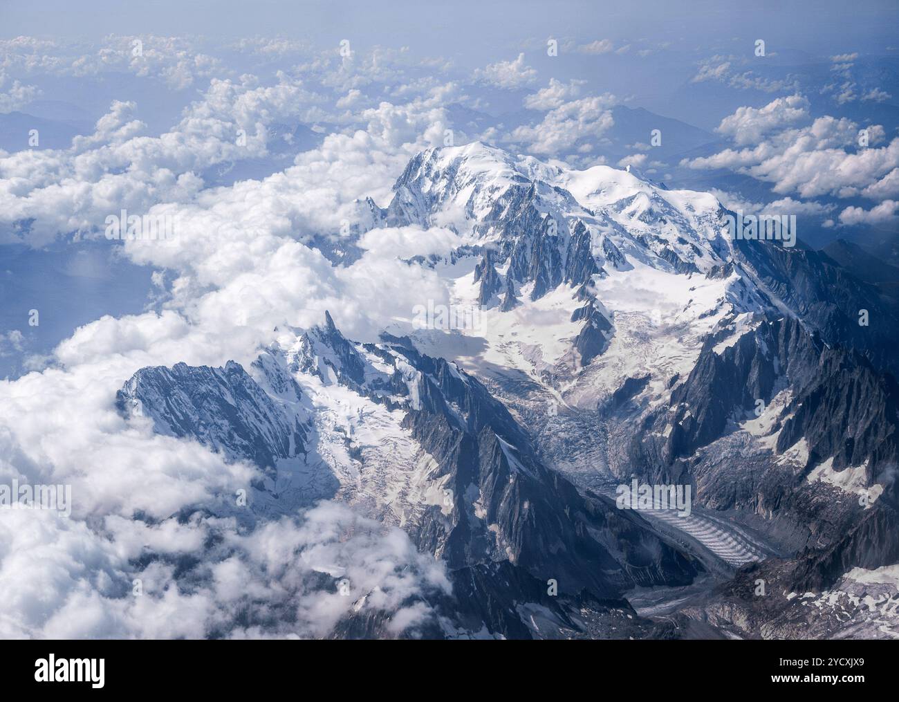 Atemberaubende Luftaufnahme der schneebedeckten Gipfel und Gletscher der Schweizer und französischen Alpen, die durch Wolken durchdringen. Stockfoto