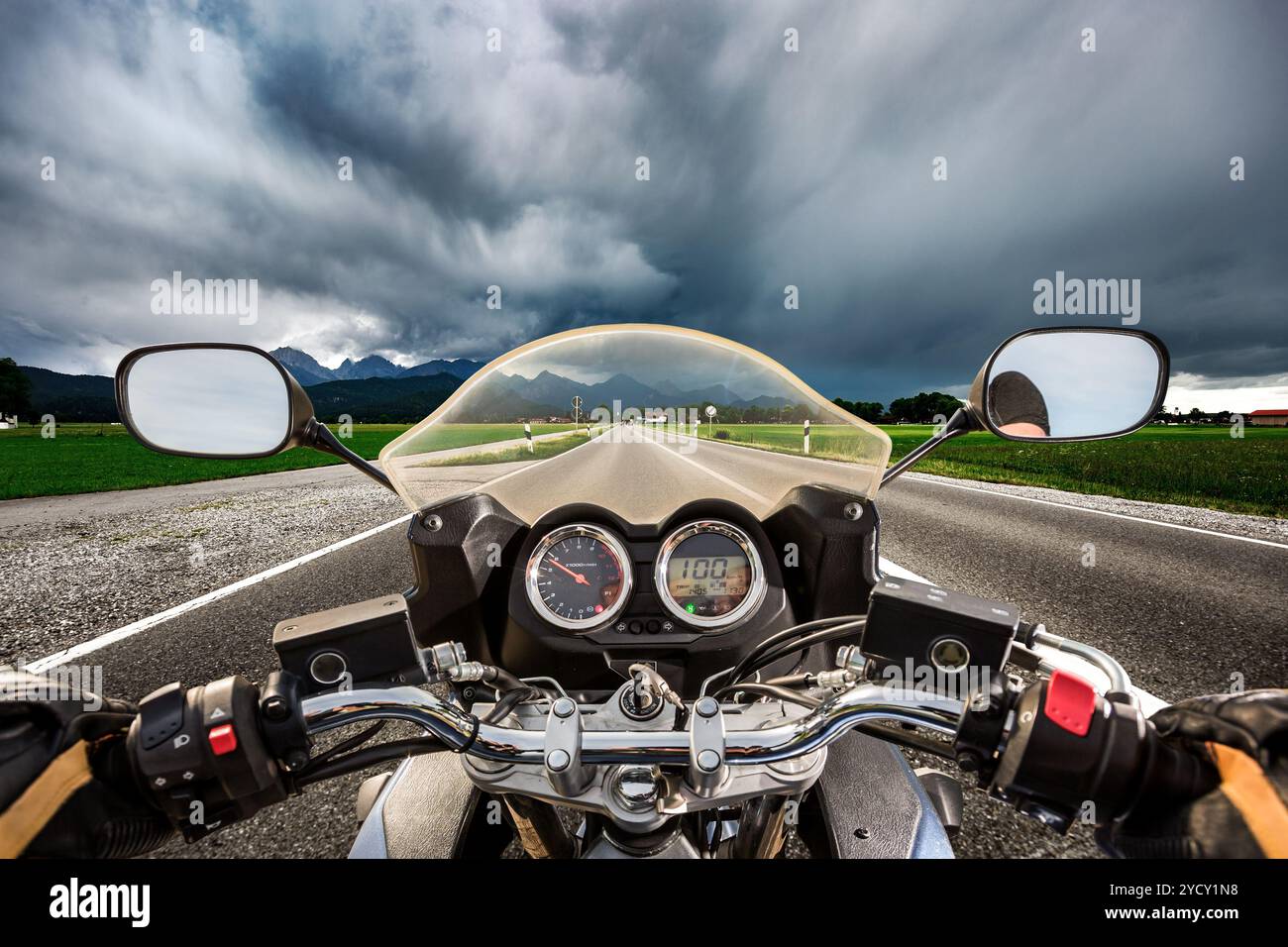 Biker auf einem Motorrad die Straße hinunter in ein Gewitter - Forggensee und Schwangau, Deutschland Bayern rast Stockfoto