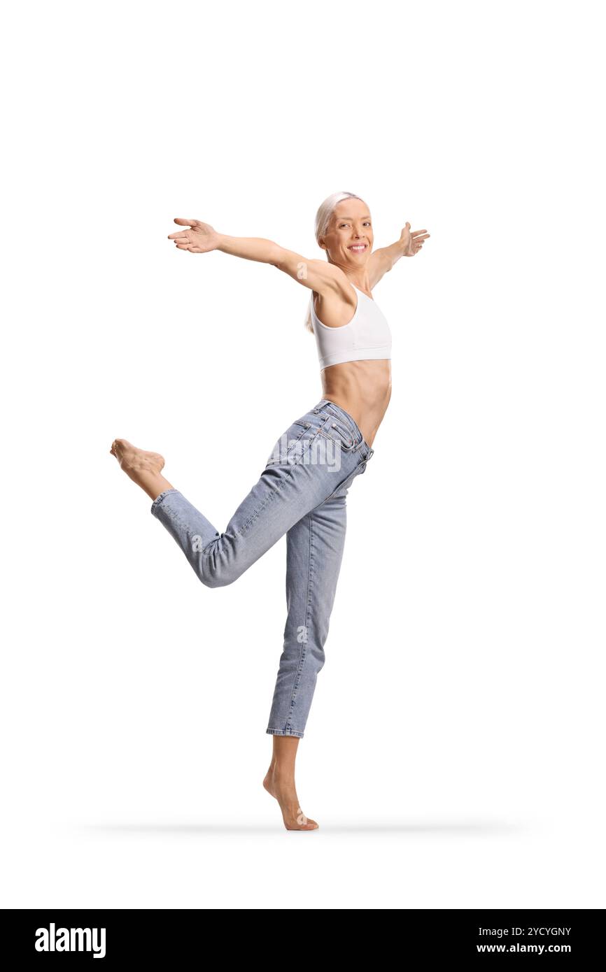 Große schlanke Frau in Jeans und weißem Crop Top, das modernes Ballett auf weißem Hintergrund tanzt Stockfoto