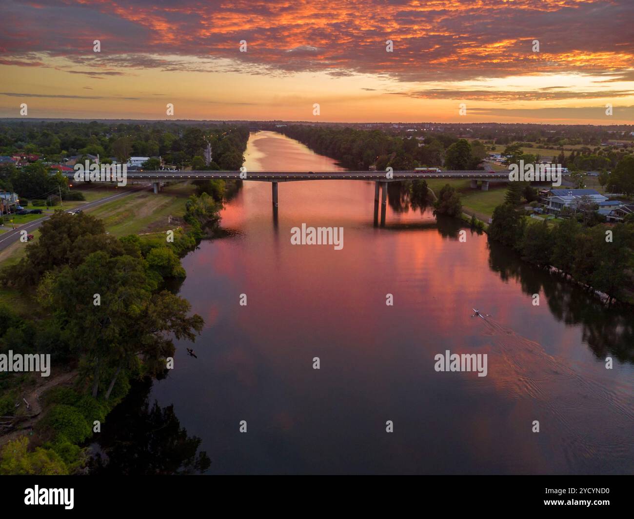 Sonnenaufgang und seine Reflexionen über den Nepean River, Blick nach Norden in Richtung Richmond. Die Autobahn M4 überquert in mittlerer Entfernung. Frühe Kajakfahrer Stockfoto