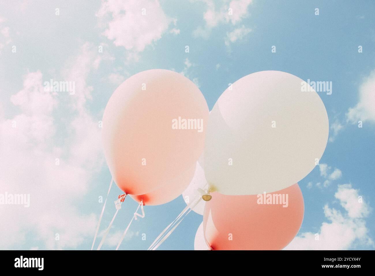 Weiße pinkfarbene Ballons gegen den Himmel. Himmel mit Wolken Stockfoto