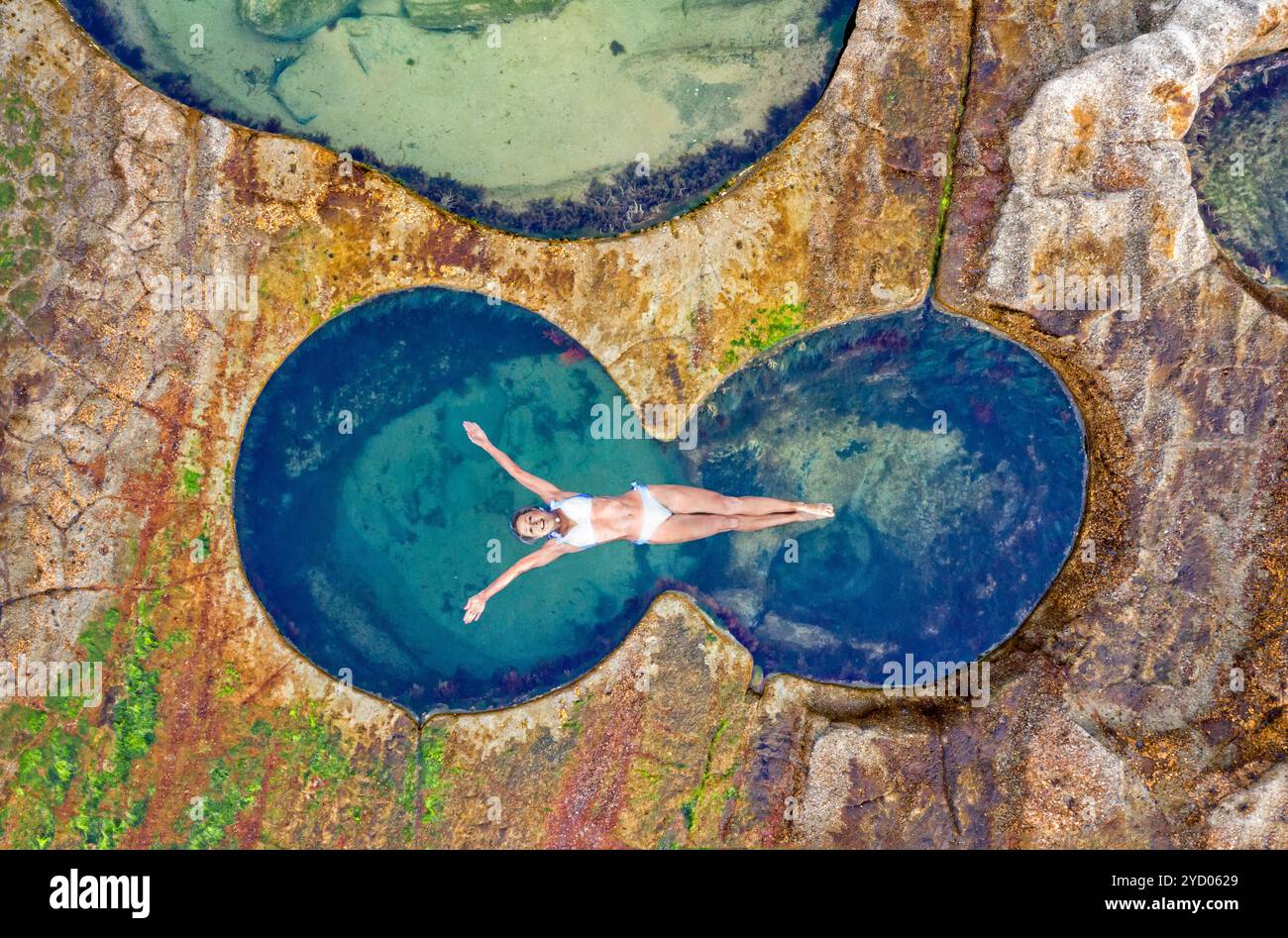 Frau schwimmt im idyllischen Ozean Felsenpool einfach nur Glückseligkeit Stockfoto