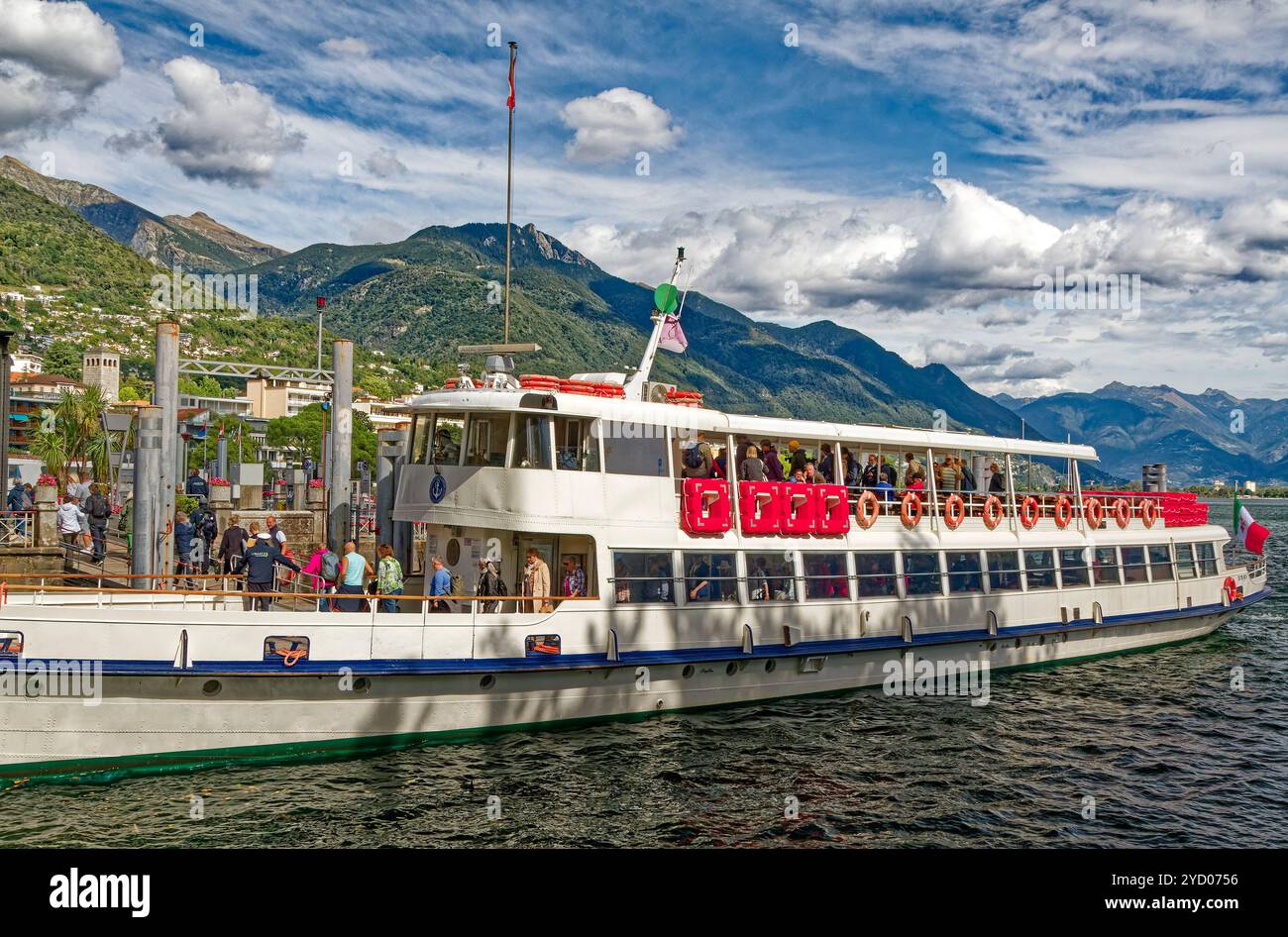 Tourboot angedockt, Leute aussteigen, Lago Maggiore, Wasser, Berge, bewölkter Himmel, Erholung, Urlaub, Sightseeing, Lebenserhaltung, Europa, Locarn Stockfoto