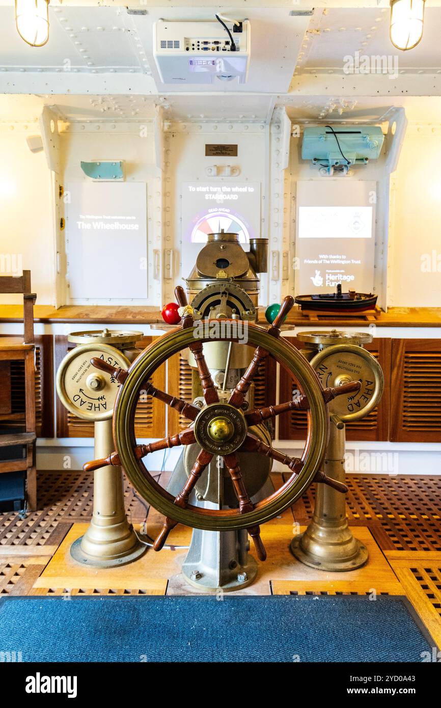 Die Brücke mit dem Schiffsrad und Navigationsinstrumenten an Bord des 1934 ehemaligen Schiffes der Royal Navy HMS Wellington, London, England Stockfoto