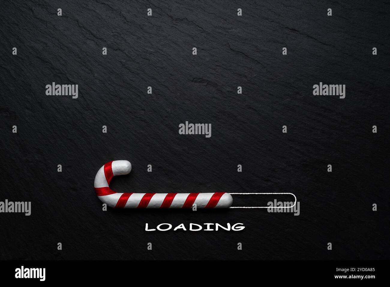 Kreatives Weihnachtskonzept aus Zuckerrohr auf schwarzem Steinhintergrund. Minimales weihnachtliches Ladekonzept. Stockfoto