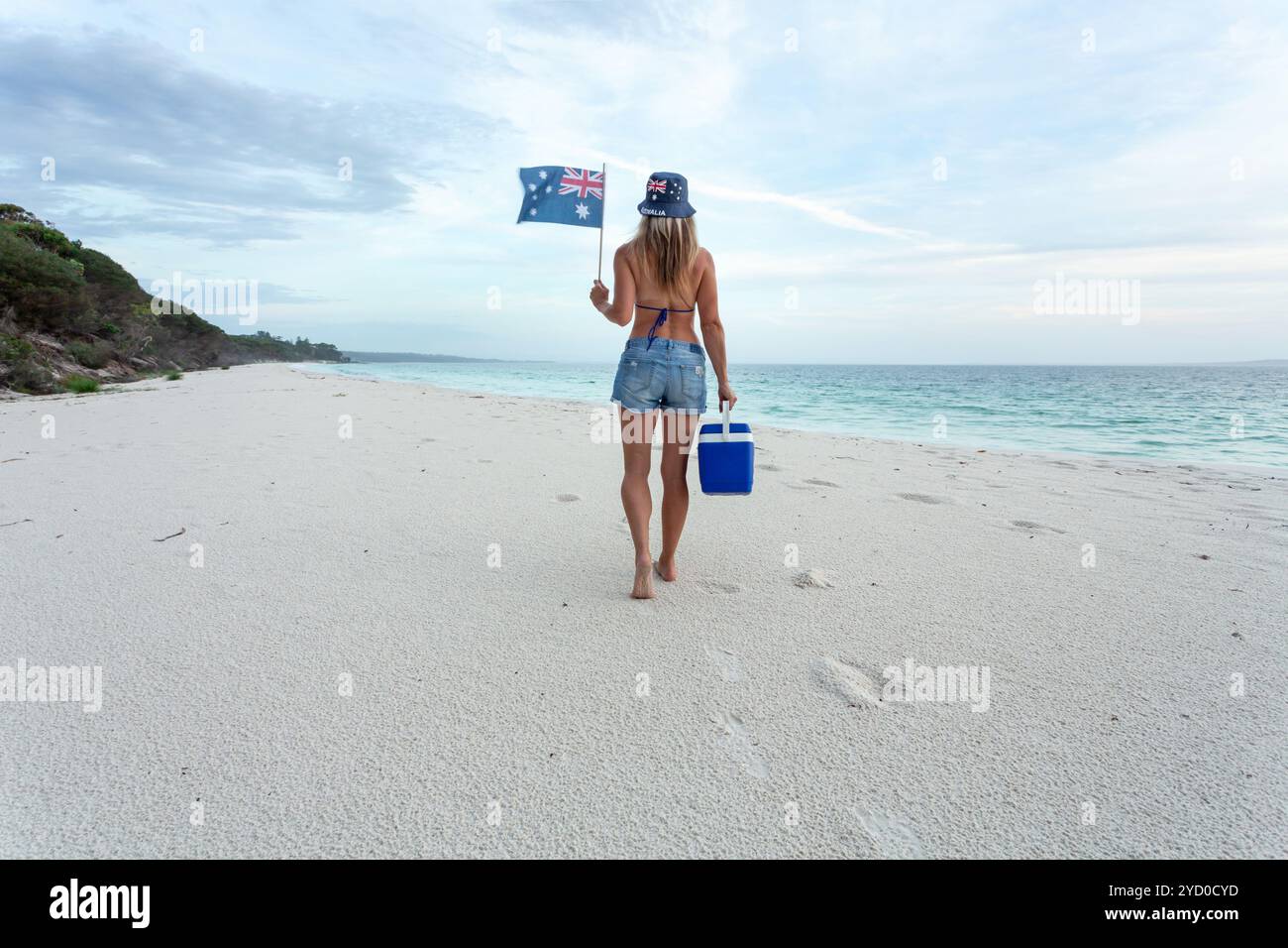 Australische Strandkultur Frau, die mit esky am Strand spaziert Stockfoto