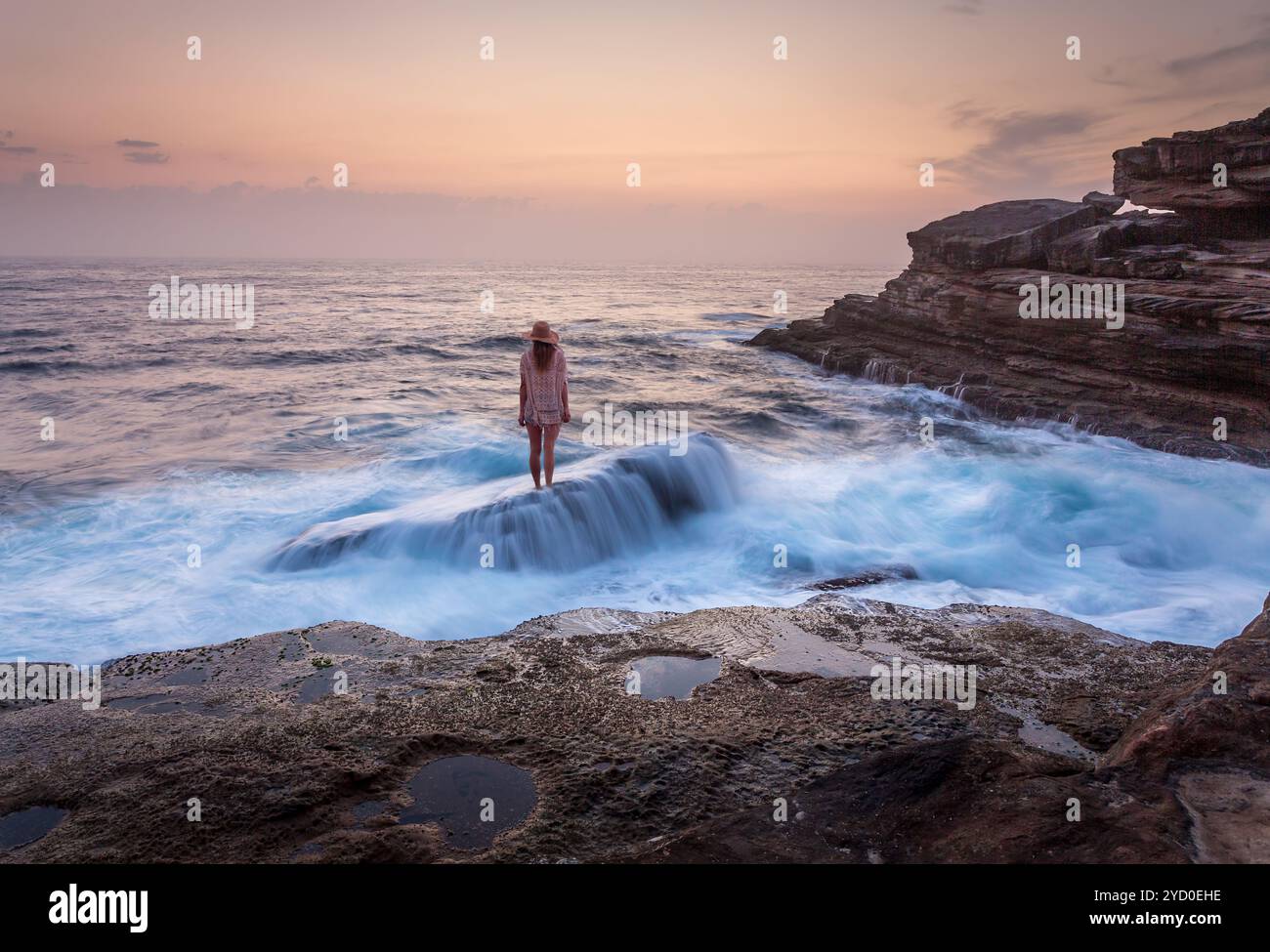 Frau, die auf einem Schiffswrack steht, über dem Meer fließt Stockfoto