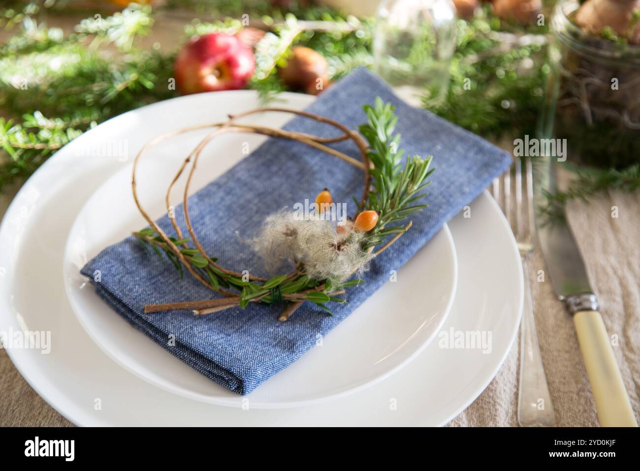 Ein natürlicher, handgefertigter Weihnachtstisch mit einfachen, handgefertigten, festlichen Details, die den Geist der Saison auf den Tisch bringen. Stockfoto