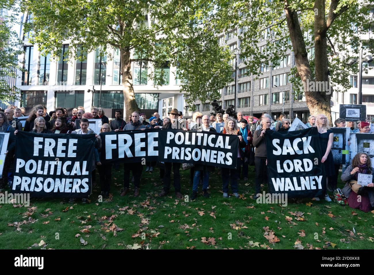 London, Großbritannien. 24. Oktober 2024. Anhänger der Wahlkampfgruppe verteidigen unsere Jurys halten Fotos von politischen Gefangenen, Vergangenheit und Gegenwart, außerhalb des Justizministeriums in Petty France, in einer Ausstellung und stillen Protest gegen drakonische Strafen, die an Klima- und andere gewaltlose Aktivisten verhängt wurden. Sie fordern ein öffentliches Treffen mit dem neuen Generalstaatsanwalt der Labour-Regierung, Lord Hermer, um über Proteste gegen die Protestgesetzgebung zu diskutieren, für ein Ende der "undemokratischen Lobbyarbeit" durch rechte Gruppen und die Entlassung von Lord Walney. Quelle: Ron Fassbender/Alamy Live News Stockfoto