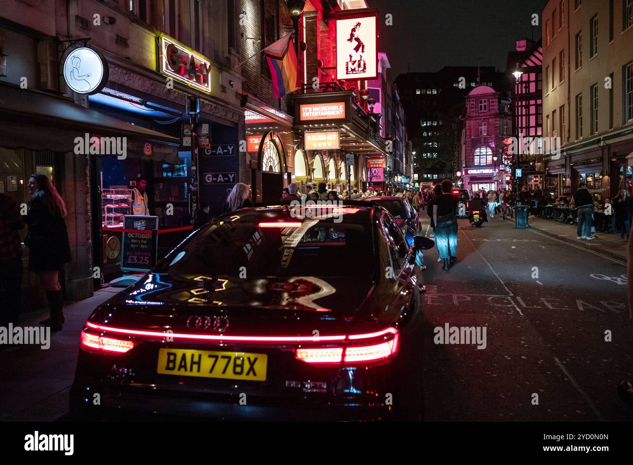 Old Compton Street, im Herzen von Soho, Londons West End, beleuchtet von Theater und Autolichtern während der Abendzeit, London, England, Großbritannien Stockfoto