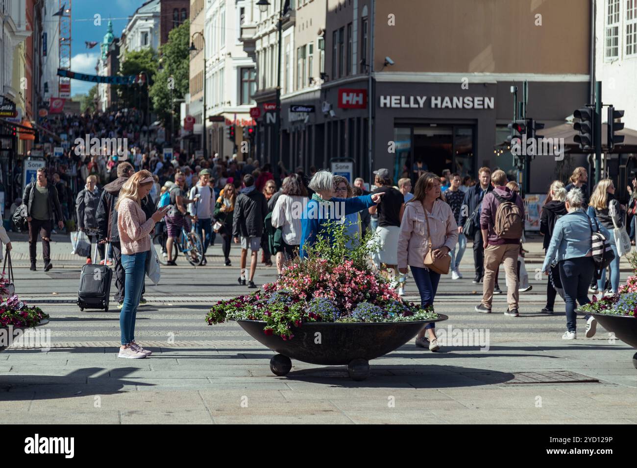 Oslo, Norwegen - 18. August 2018: Geschäftige Einkaufsstraße in der Innenstadt von Oslo mit einer jungen Frau am Telefon inmitten von Menschenmassen Stockfoto