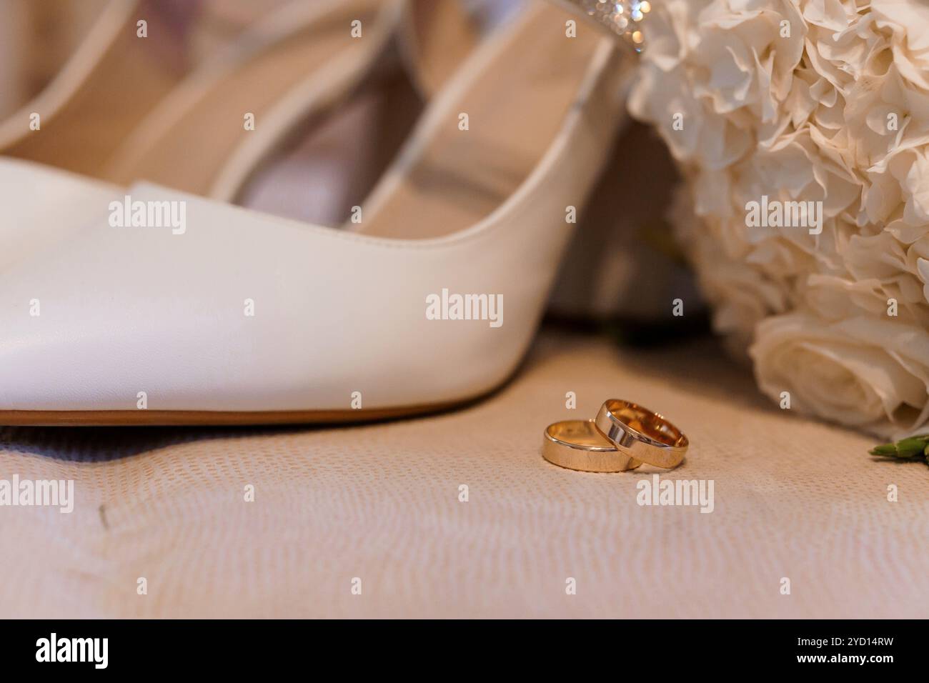 Elegante Hochzeitsdetails mit Brautschuhen und Ringen. Stockfoto