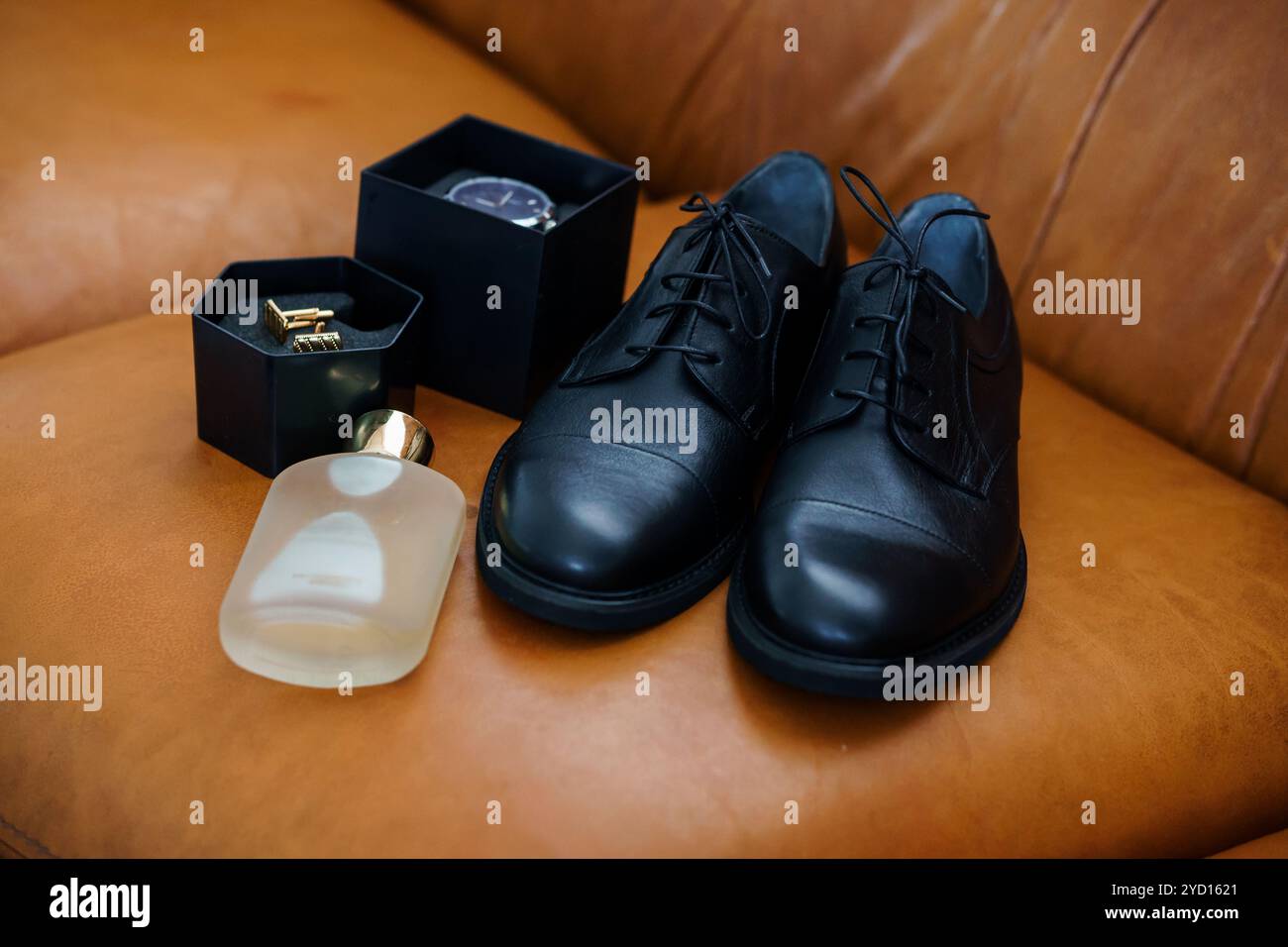 Elegante Herrenmode-Accessoires auf einem braunen Ledersofa. Stockfoto