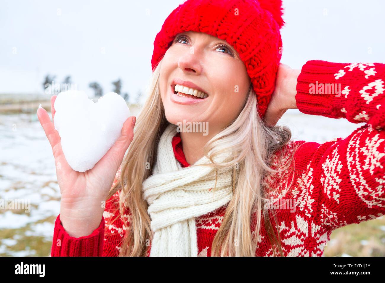 Frau, die ein Schneeherz hält. Weihnachts- oder Winterthema Stockfoto