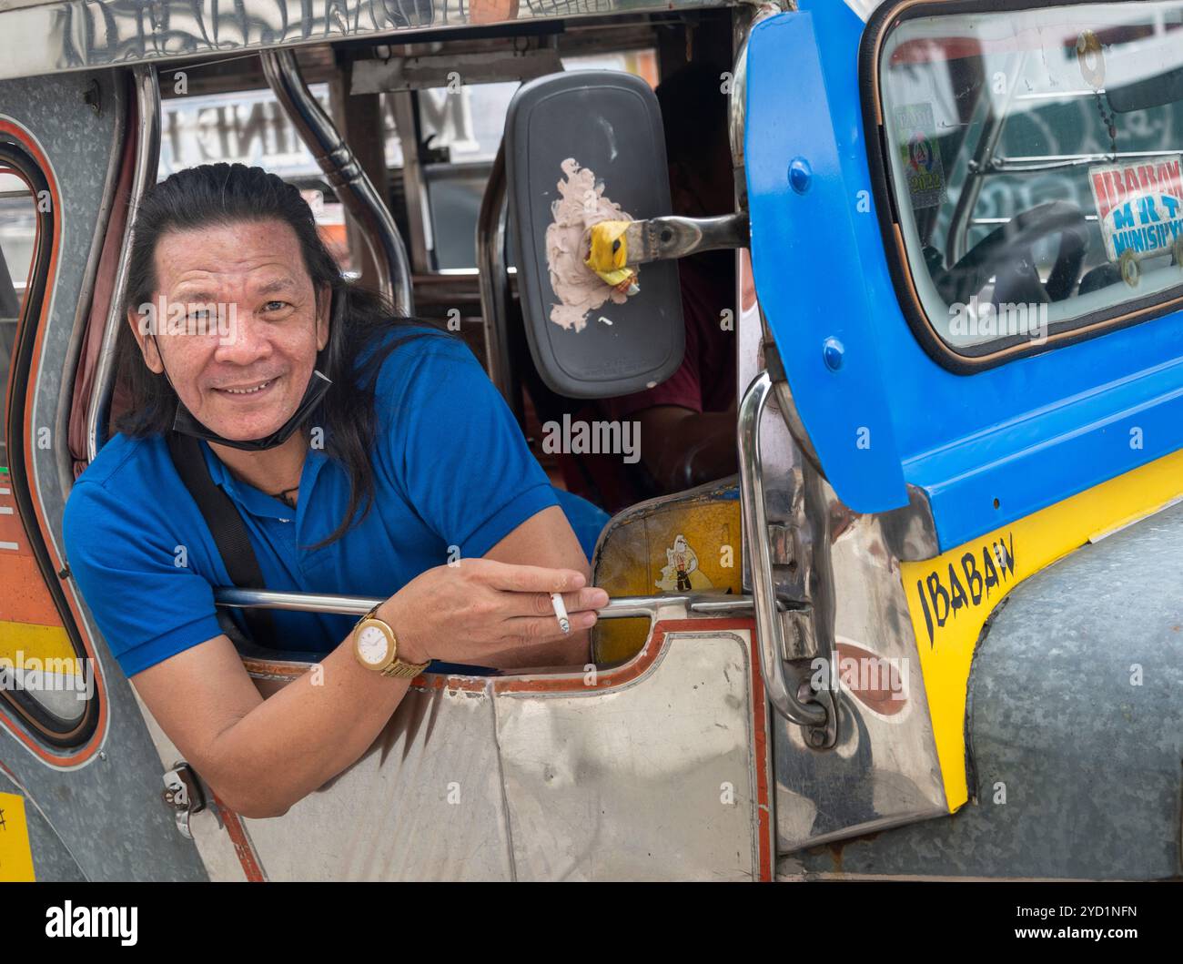 Manila-13. Januar 2023: Porträt des freundlichen philippinischen Jeepney-Fahrers, der sich aus seinem Fenster lehnte und lächelte, während der d Stockfoto