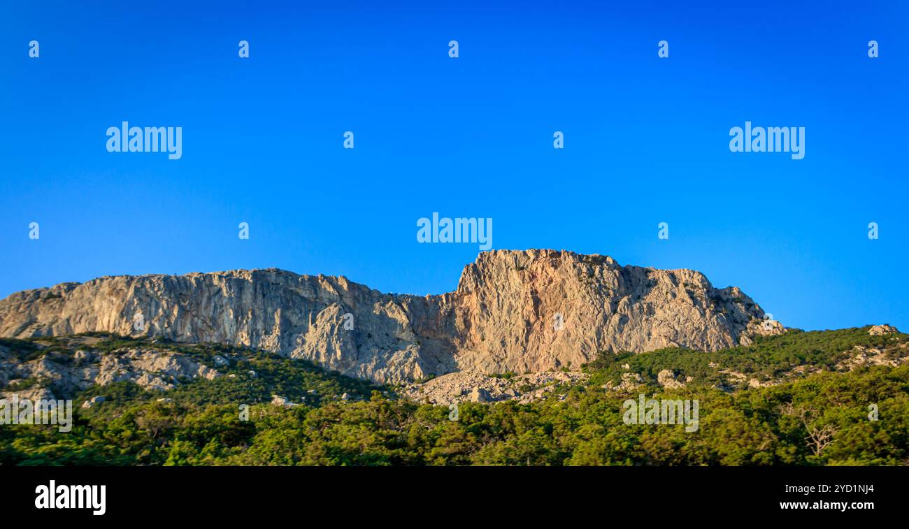Russische Berge. Krim. Sommer Berge Hintergrund. Wald und Berge in der Sonne vor dem Hintergrund eines bewölkten Himmels darüber Stockfoto